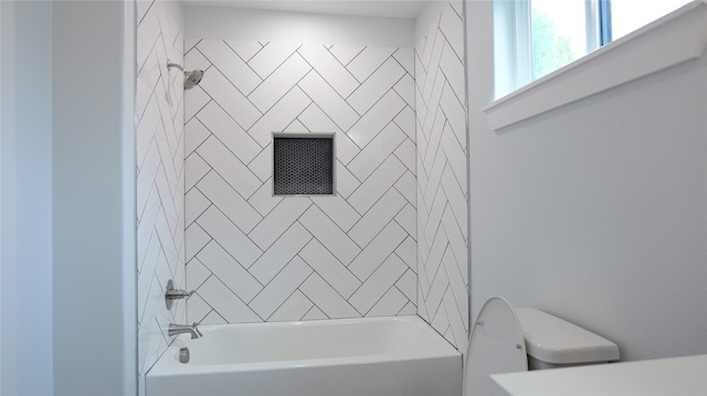 bathroom with tiled shower / bath and toilet