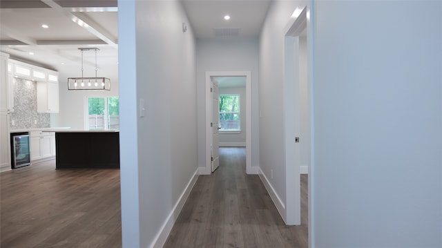 hall featuring dark hardwood / wood-style floors, beam ceiling, and beverage cooler