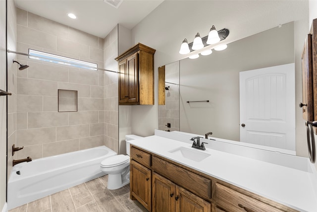 full bathroom with toilet, tiled shower / bath combo, hardwood / wood-style flooring, and vanity