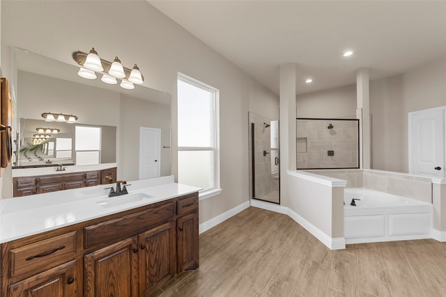 bathroom featuring vanity, hardwood / wood-style floors, and plus walk in shower