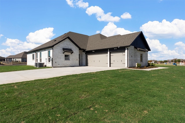 view of front of house featuring cooling unit, a garage, and a front lawn