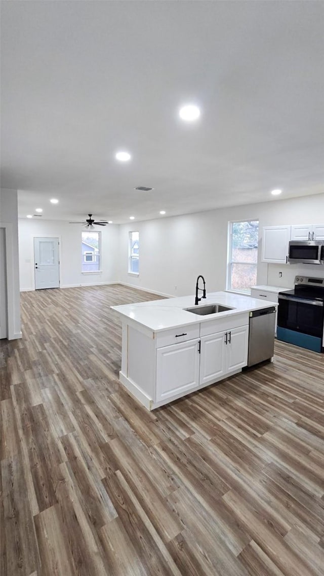 kitchen featuring white cabinetry, sink, appliances with stainless steel finishes, and light hardwood / wood-style flooring