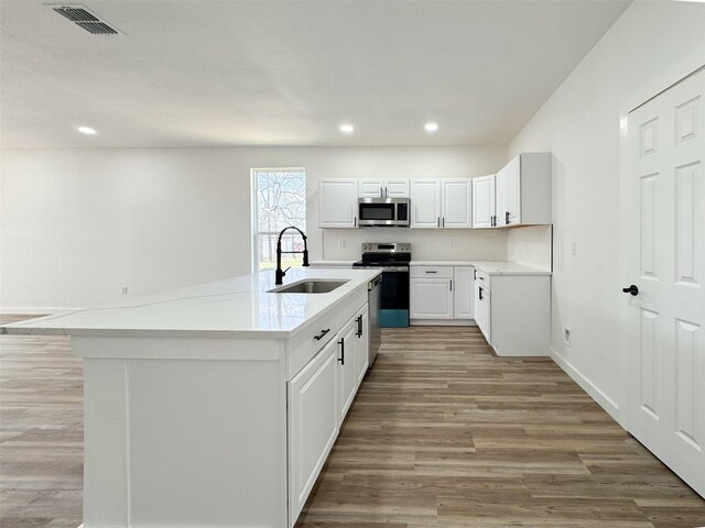 kitchen with white cabinets, light wood-type flooring, sink, and appliances with stainless steel finishes