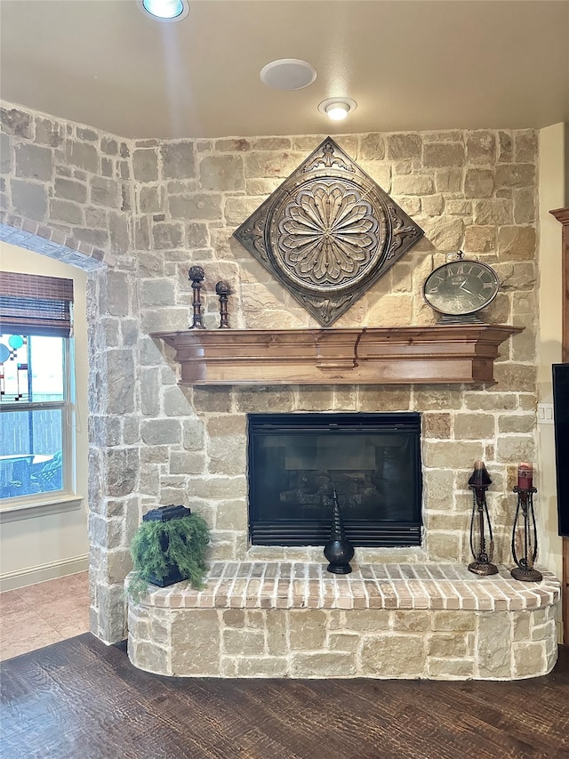 details with a stone fireplace and hardwood / wood-style flooring