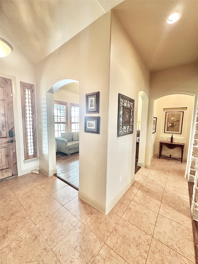 tiled entrance foyer featuring a textured ceiling and vaulted ceiling