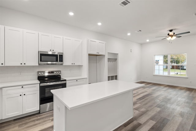 kitchen featuring white cabinets, stainless steel appliances, and a kitchen island