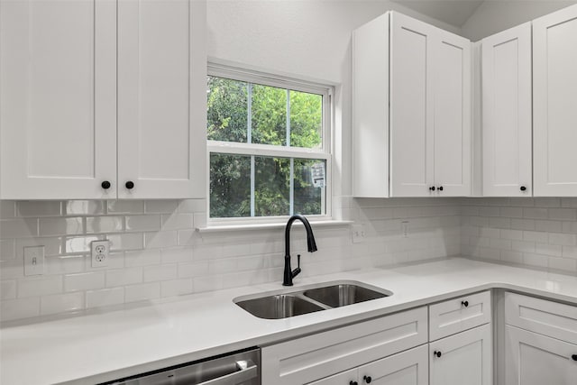 kitchen featuring tasteful backsplash, dishwasher, sink, and white cabinets