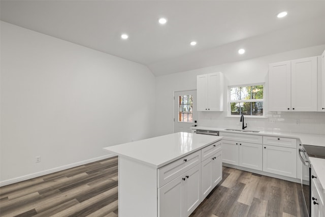 kitchen with dark hardwood / wood-style flooring, white cabinetry, a kitchen island, and sink