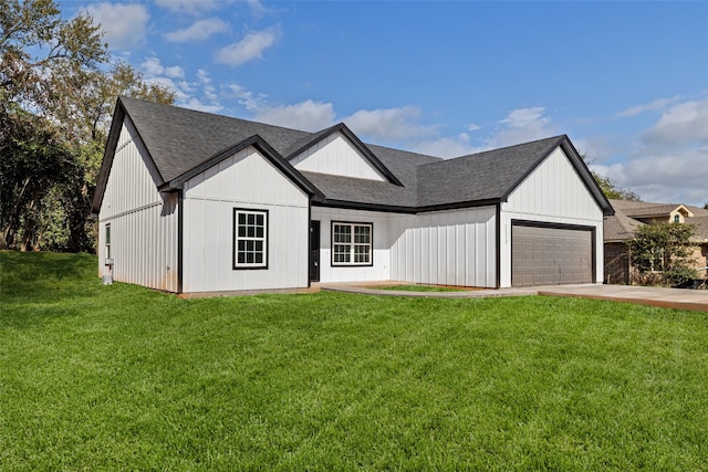 modern farmhouse featuring a garage and a front lawn