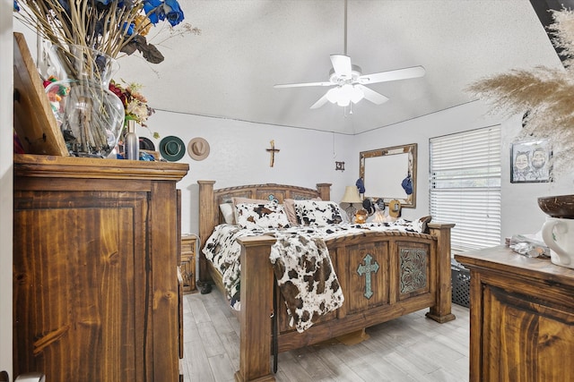 bedroom with light hardwood / wood-style floors, a textured ceiling, and ceiling fan