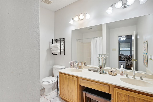 bathroom featuring toilet, ceiling fan, tile patterned floors, walk in shower, and vanity