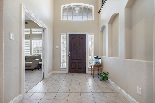 tiled foyer with a towering ceiling