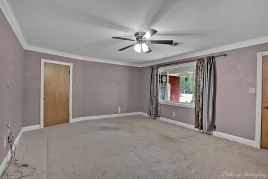 empty room with light carpet, crown molding, and ceiling fan