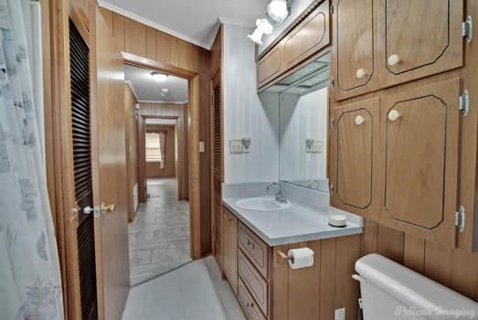 bathroom featuring toilet, tile patterned flooring, ornamental molding, and vanity