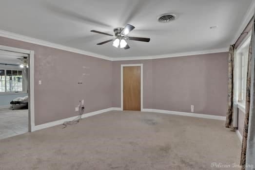 unfurnished bedroom featuring light carpet, ornamental molding, and ceiling fan