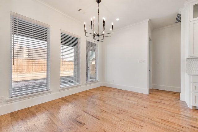 unfurnished dining area featuring a notable chandelier, light hardwood / wood-style floors, and crown molding