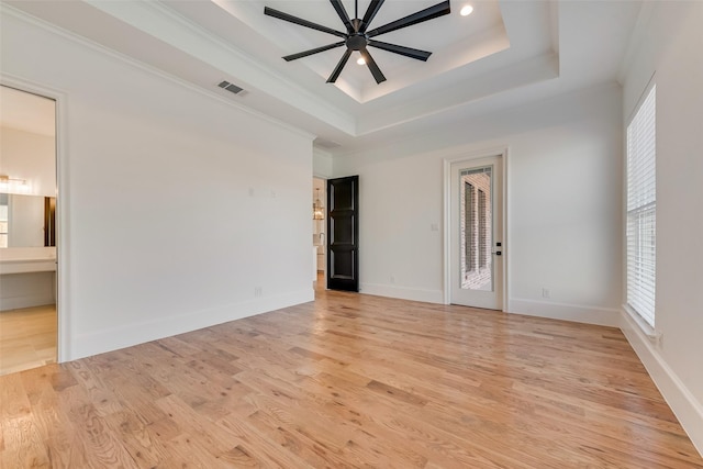 spare room featuring ornamental molding, a raised ceiling, ceiling fan, and light hardwood / wood-style floors