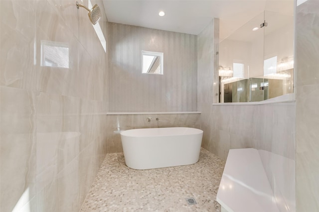 bathroom featuring tile walls and a bath