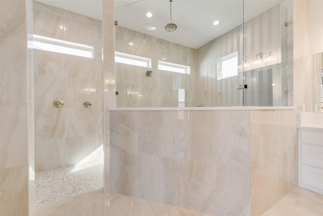 bathroom featuring a tile shower and vanity