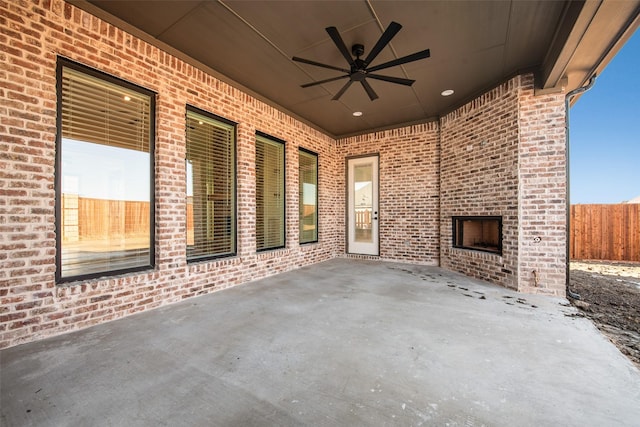 view of patio with ceiling fan and an outdoor brick fireplace