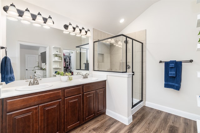 bathroom featuring a shower with door, vanity, hardwood / wood-style floors, and lofted ceiling