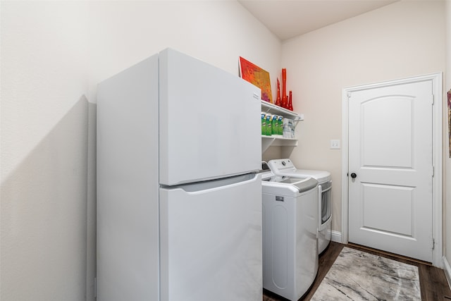 washroom with dark wood-type flooring and washing machine and clothes dryer