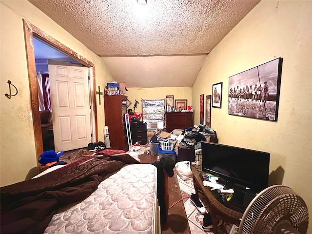 bedroom featuring a textured ceiling and vaulted ceiling