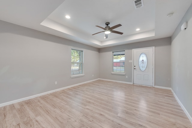 entryway featuring ceiling fan, a tray ceiling, and light wood-type flooring