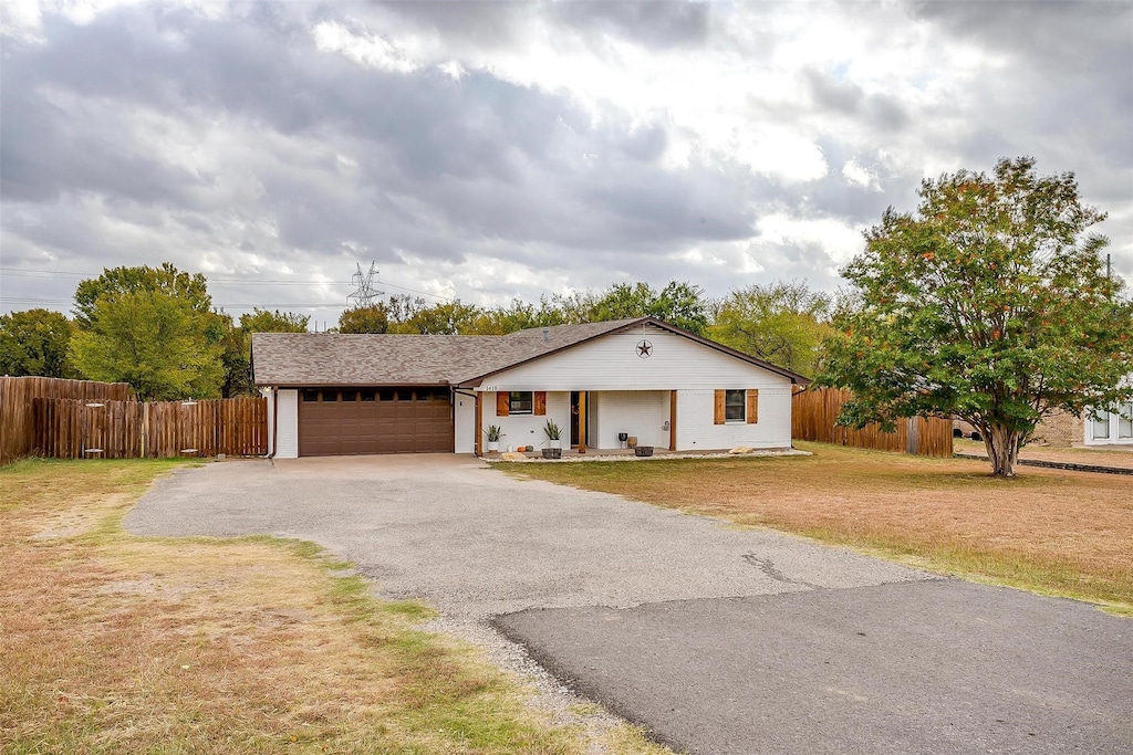 single story home featuring a garage and a front yard