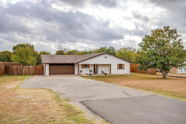 single story home featuring a garage and a front yard