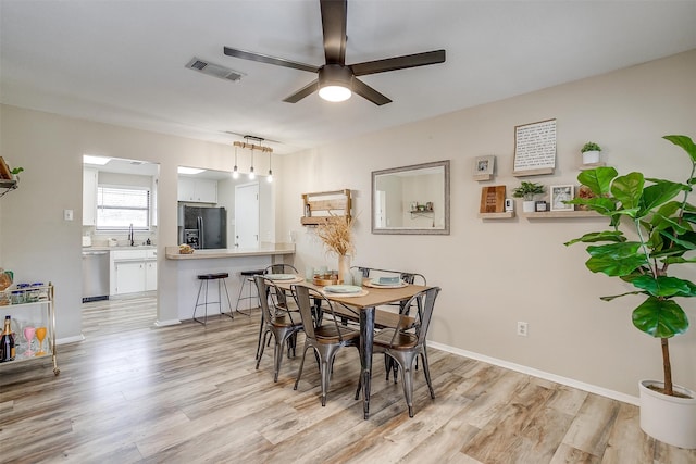 dining room with ceiling fan, light hardwood / wood-style flooring, and sink