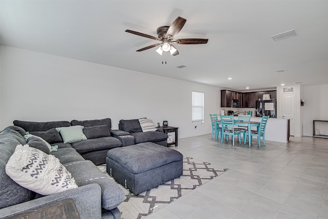 tiled living room with ceiling fan