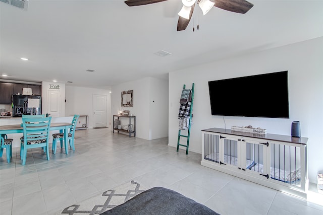 living room featuring light tile patterned flooring and ceiling fan