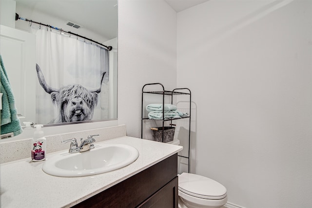 bathroom featuring toilet and vanity