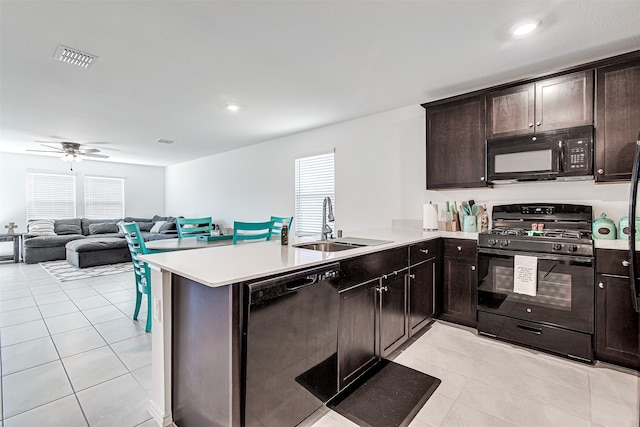 kitchen featuring kitchen peninsula, sink, black appliances, dark brown cabinetry, and ceiling fan