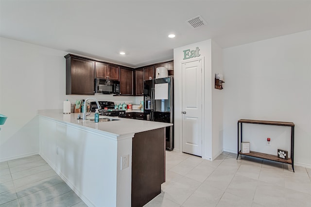 kitchen featuring kitchen peninsula, light tile patterned flooring, black appliances, dark brown cabinetry, and sink