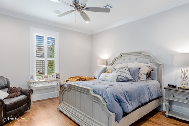 bedroom with hardwood / wood-style flooring, ornamental molding, and ceiling fan