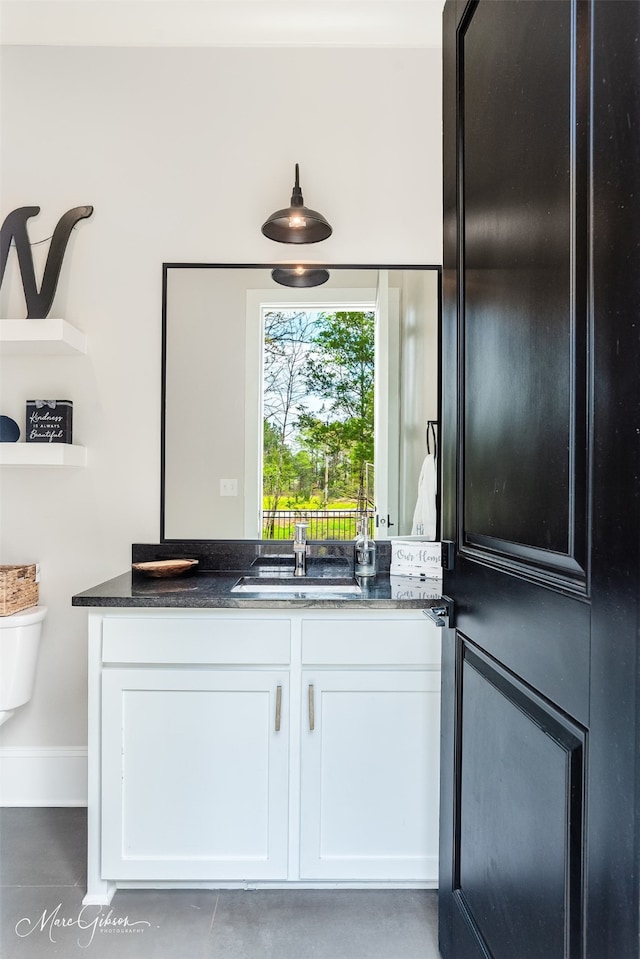 interior space featuring dark stone countertops, sink, and white cabinets