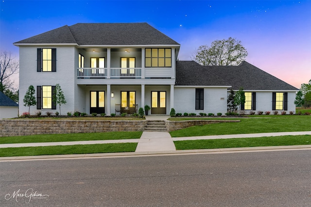 view of front facade with a yard and a balcony