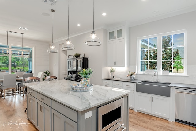 kitchen featuring pendant lighting, sink, white cabinets, dark stone counters, and stainless steel appliances