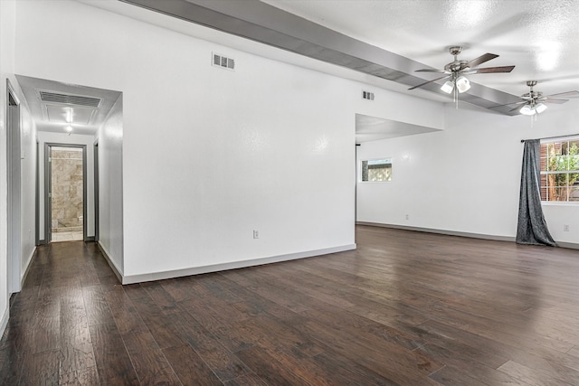 unfurnished room with a textured ceiling, dark wood-type flooring, and ceiling fan