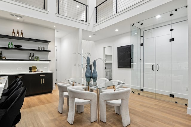 dining area with a high ceiling and light wood-type flooring