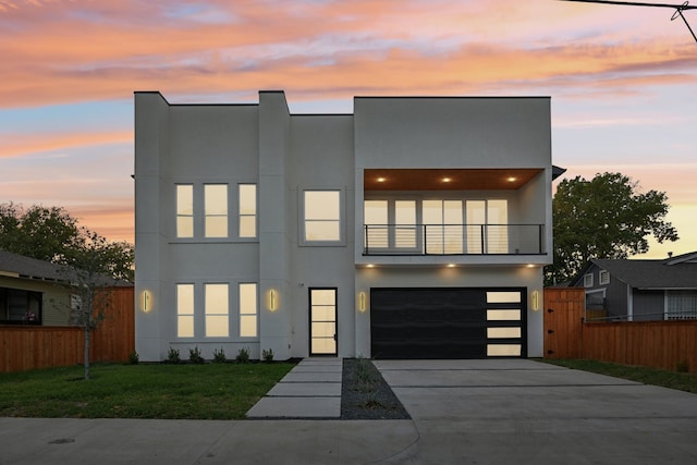 modern home with a balcony, a yard, and a garage