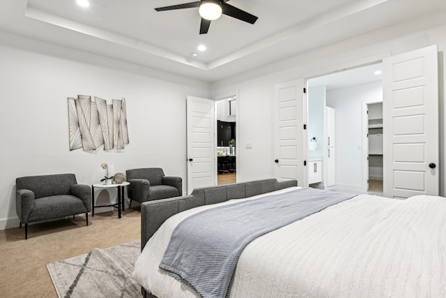 bedroom with light carpet, a raised ceiling, and ceiling fan