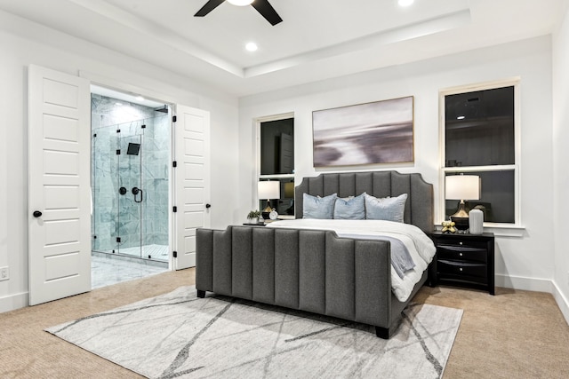 carpeted bedroom with a raised ceiling and ceiling fan