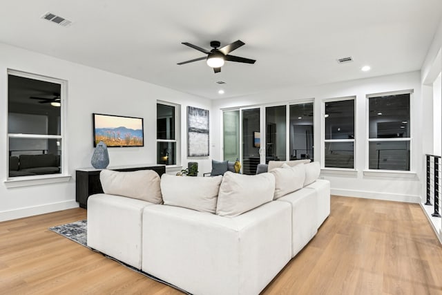 living room featuring light wood-type flooring and ceiling fan