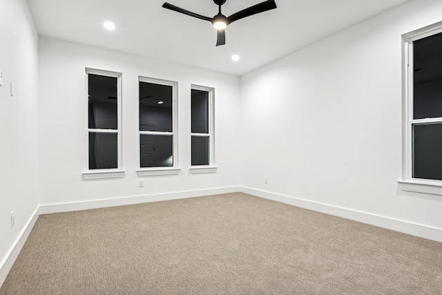 carpeted spare room with ceiling fan