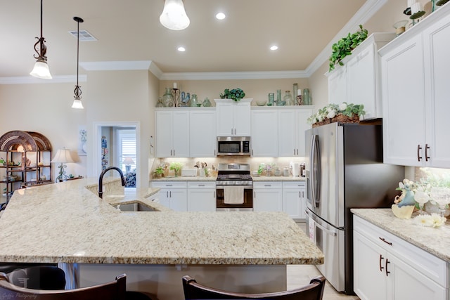 kitchen featuring pendant lighting, a center island with sink, a breakfast bar area, and appliances with stainless steel finishes