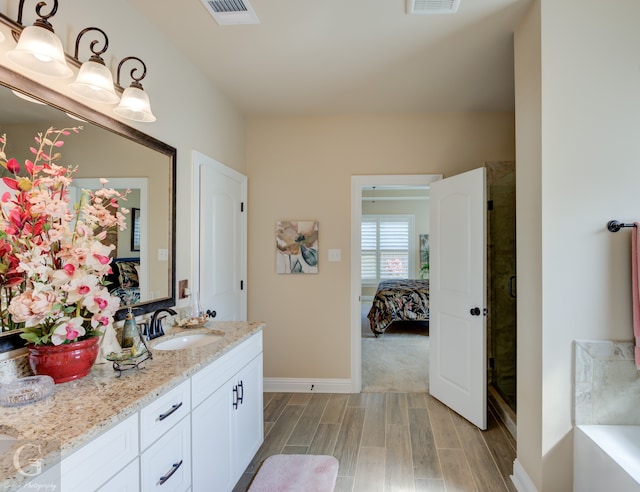 bathroom with hardwood / wood-style flooring, vanity, and a shower with door