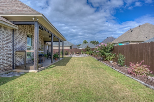 view of yard with ceiling fan and a patio area